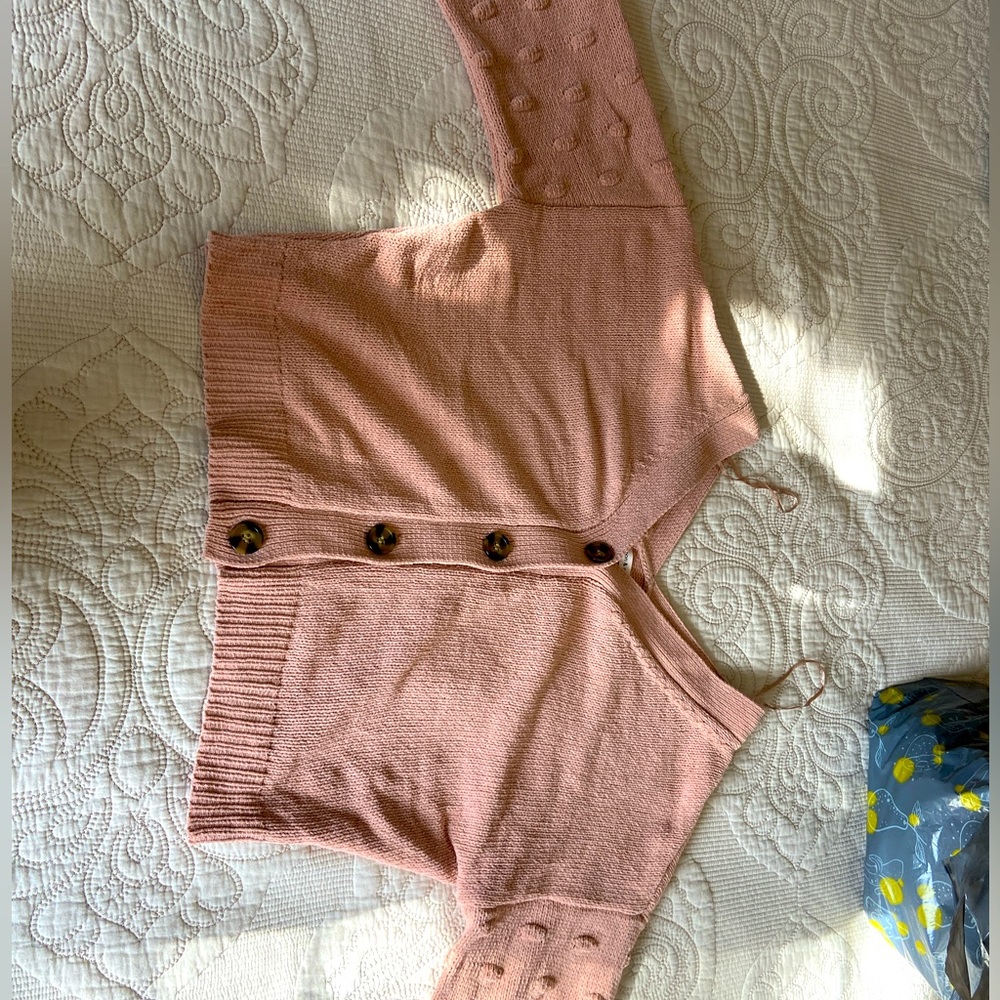 Pink knitted button up sweater.